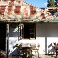 A table for 4 sits outside under the window of an old 1850s Welsh miner's cottage called Russell's Pizza 