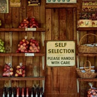 Apple bags line wooden shelfs at an apple stand on the side of the road in Kenton Valley in the Adelaide Hills