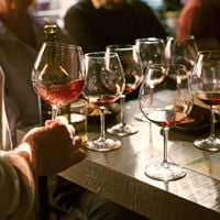 A close up of 7 wine glasses filled with red wine at Mothervine for a tasting flight 