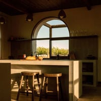 Shadows cast a warm glow over the kitchen at Rare Earth Retreats which looks out to blue skies and vineyards 