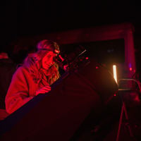 Someone looks into a big telescope during a Juggle House Experiences stargazing tour 